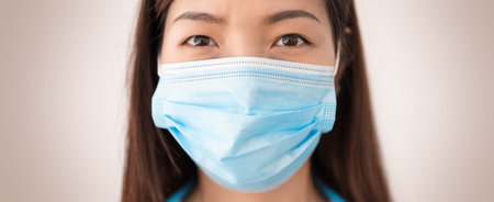 Closeup of asian woman wearing protective mask and looking at the camera. Concept of protect...