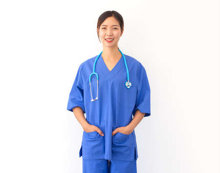 portrait of attractive young asian nurse wearing blue uniform and stethoscope isolated on white backgrooundの写真素材