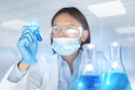 Blurred woman chemist holding a test-tube examines chemical solution in laboratory. Biochemistry...