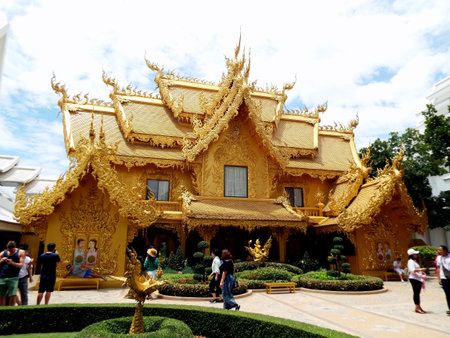 Chiang Rai. Thailand, June 17, 2017: Wat Rong Khun. The public strolls past the golden bathhouse building at the White Temple in Chiang Rai, Thailand. Designed by Don Chalermchai Kositpipatのeditorial素材