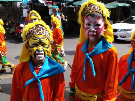 Bangkok, Thailand, November 14, 2015: Two boys with painted faces and colorful dresses in the parade...