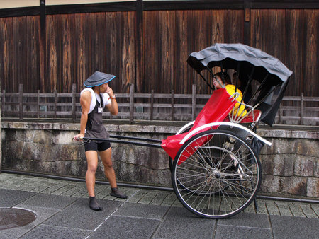 Kyoto, Japan, July 13, 2016: A boy and a girl in a typical rickshaw on a street in Kyoto
