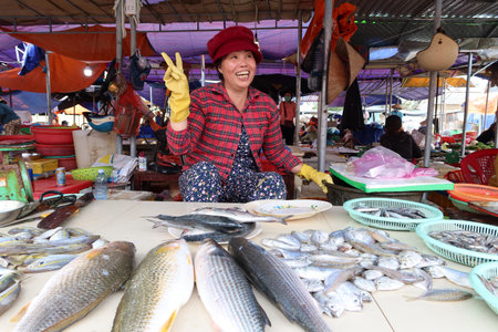 Hoi An, Vietnam, November 16, 2020: A woman greets smiling at a fish stall in the Ba Le market in Hoi Anのeditorial素材
