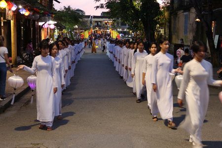 Hoi An, Vietnam, December 28, 2020: Girls dressed in white with lanterns in hand parading on a street during Integration - Lighten up Hoi An event that took place in town on December 28th 2020のeditorial素材