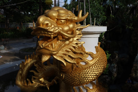 Hoi An, Vietnam, September 22, 2021: Golden dragon head in a fountain in the gardens of Nam Ton Templeのeditorial素材