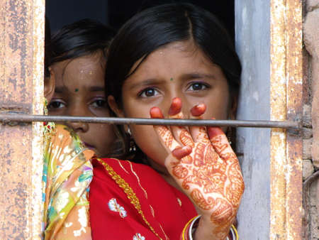 Rajasthan, India, August 15, 2011: Schoolgirl with colorful clothes and hand dyed with henna in the window of a school at the celebration of India's independence dayのeditorial素材