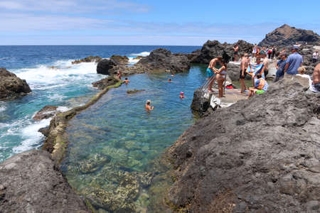 Garachico, Tenerife, Canary Islands, Spain, July 6, 2022: Many tourists enjoy the sun and sea water in one of the natural pools El Caleton, Garachico, Tenerife. Spainのeditorial素材