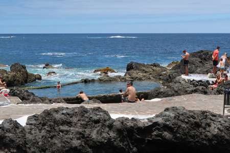 Garachico, Tenerife, Canary Islands, Spain, July 6, 2022: Tourists enjoying a sunny day in the El Caleton natural pools, Garachico, Tenerife. Spainのeditorial素材