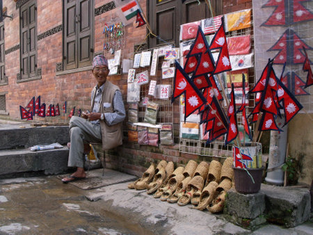 Kathmandu, Nepal, August 20, 2011: An elderly man sells Nepalese flags and handicrafts on a street in Kathmandu. Nepal.のeditorial素材