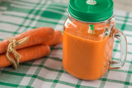 Carrot juice in glass and fresh carrots. Healthy food.の写真素材