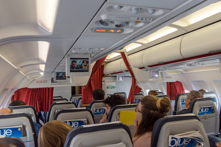 Warsaw, Poland, May 16, 2017: Interior of airplane with passengers on seats. In-flight monitors attached on the ceiling. Aegean Airlines.のeditorial素材