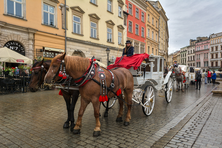 KRAKOW, POLAND - August 6, 2016: Horse carriage at main square in Krakow in rainy day. Poland. Europe.のeditorial素材