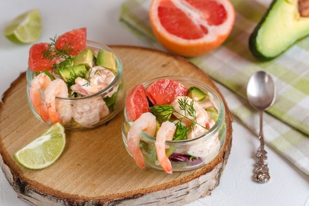 Cocktail salad with shrimp, avocado, green lettuce, grapefruit and mayonnaise sauce in a glass.の写真素材