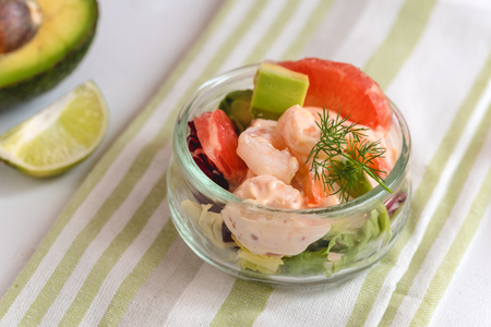 Cocktail salad with shrimp, avocado, green lettuce, grapefruit and mayonnaise sauce in a glass.の写真素材