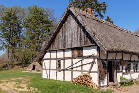 Typical whitewashed house with thatched roof in open-air museum in Kluki village. Polandのeditorial素材