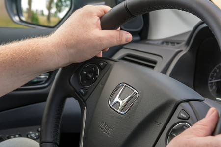 POLAND - July 8, 2018: Man holding Honda CR-V steering wheel while driving.のeditorial素材