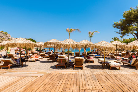 RHODES, GREECE - May 13, 2018: Toursits sunbathing on the beach in the Kallithea Springs in Rhodes, Greeceのeditorial素材
