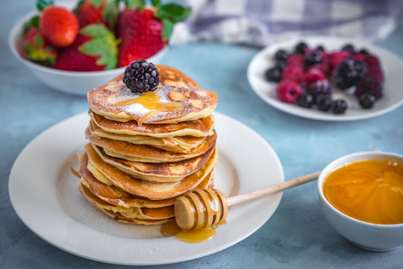 Fluffy and delicate pancakes with honey and berries.の写真素材