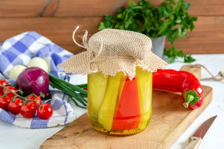 Jar of pickled cucumbers and red pepper. Marinated and canned vegetables food.の写真素材