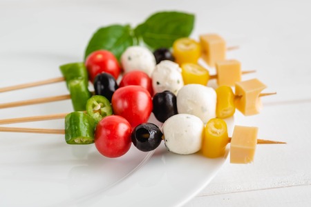 Appetizer on stick with various vegetables and cheese.の写真素材