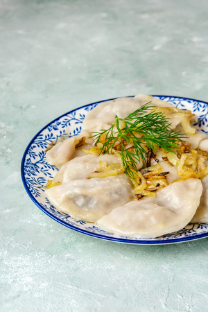 Traditional Ukrainian dumplings, filled with mashed potato and cabbage. Vareniki with filling. Vegetarian dish.の写真素材