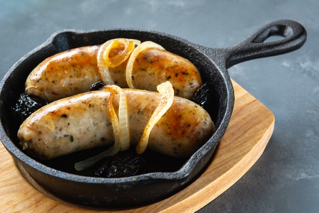 White sausage fried with onions and dried plums.の写真素材