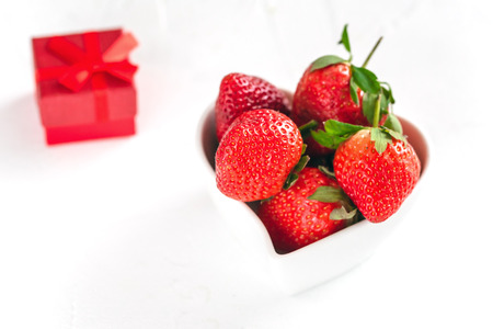 Fresh strawberries in a heart shaped bowl isolated on white background. Valentine Day.の写真素材