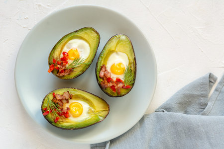 Quail eggs baked in avocado with bacon, red paprika and dill.
