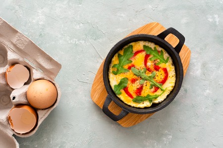 Omelette with fresh pepper and arugula. Frittata in frying pan.の写真素材