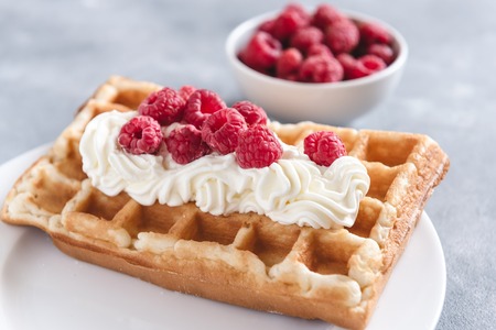 Homemade waffles with raspberries and creamの写真素材