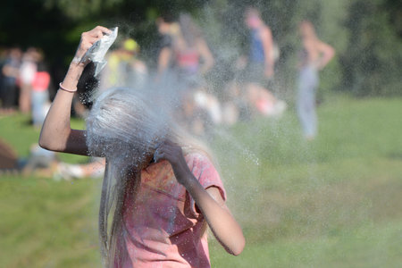GDANSK, POLAND - June 22, 2019: Young girl throwing colorful powder, taking part in Festival of...