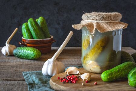 Pickled cucumbers with herbs and spices on dark backgroundの写真素材