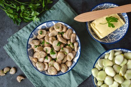Boiled broad beans served in a bowl with butter and parsleyの写真素材