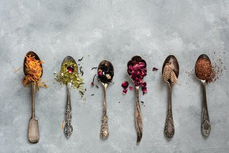 Different types of dry tea in vintage spoons. Flat layの写真素材