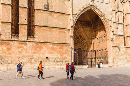 Mallorca, Spain - May 8, 2019: Tourists visit La Seu, the gothic cathedral de Palma de Mallorca on...