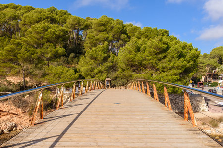 Menorca, Spain - October 14, 2019: Footbridge in Cala Galdana, a popular tourist resort on the...