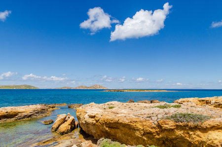 Rocky coast and sea with white cloud on the sky. Paros island. Cyclades. Greece.