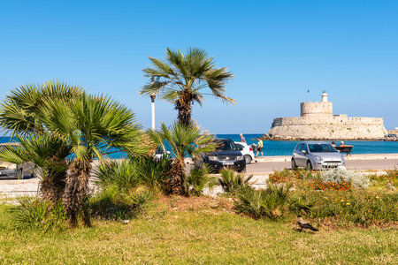 RHODES, GREECE - May 13, 2018: Palm trees growing on the seaside promenade of Rhodes