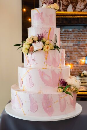 Five layered wedding cream cake decorated with flowersの写真素材