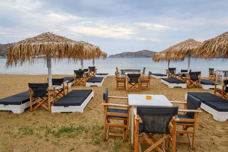 Ios, Greece - September 19, 2020: Beach loungers with umbrellas on sandy beach of Chora on Ios Island. Cyclades, Greeceのeditorial素材
