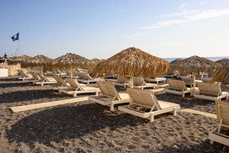 Santorini, Greece - September 16, 2020: Straw umbrellas with sun loungers at the Vlychada Beach on the southern side of Santorini, Cyclades, Greeceeのeditorial素材