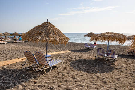 Santorini, Greece - September 16, 2020: Straw umbrellas with sun loungers at the Vlychada Beach on the southern side of Santorini, Cyclades, Greeceeのeditorial素材