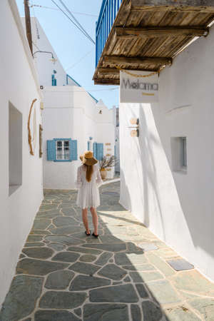 Folegandros, Greece - September 23, 2020: A young woman tourist walking on Chora town street in Folegandros, Cyclades islands, Greeceのeditorial素材
