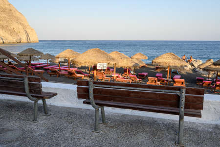 Santorini, Greece - September 16, 2020: Bench overlooking Black Beach in Perissa village on Santorini. Cyclades Islands, Greeceのeditorial素材