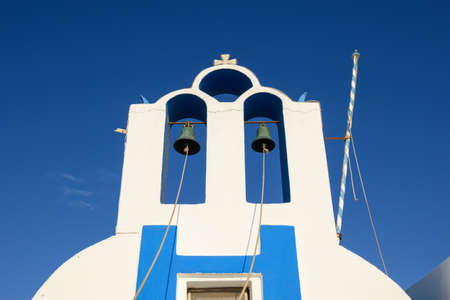 Bell tower of Greek under blue sky. Emporio village on the south side of Santorni. Cyclades Islands, Greeceの写真素材