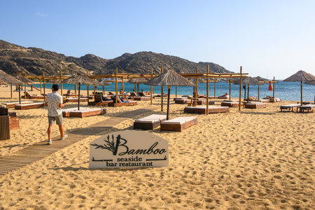 Ios, Greece - September 20, 2020: Seaside bar restaurant with sun loungers and umbrellas on Mylopotas beach on Ios Island. Greeceのeditorial素材