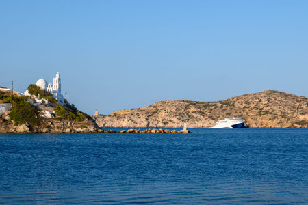 Sea bay and Greek church on the cliff, symbol of Ios island. Cyclades, Greece.