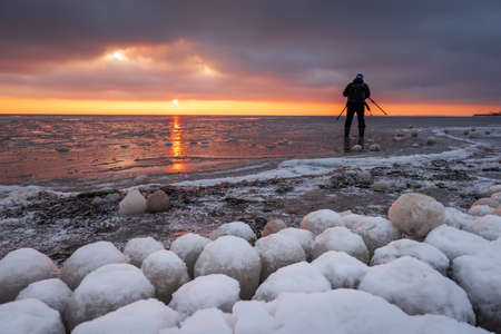 Jastarnia, Poland - January 17, 2021: The photographer takes a picture of the frozen Baltic Sea during sunsetのeditorial素材