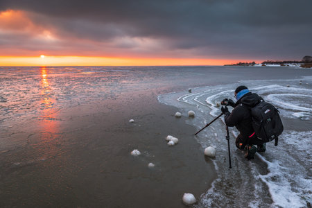 Jastarnia, Poland - January 17, 2021: The photographer takes a picture of the frozen Baltic Sea...