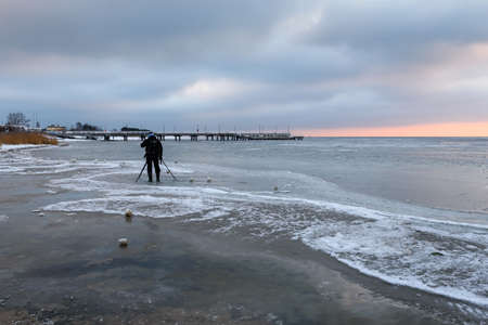 Jastarnia, Poland - January 17, 2021: The photographer takes a picture of the frozen Baltic Sea during winterのeditorial素材